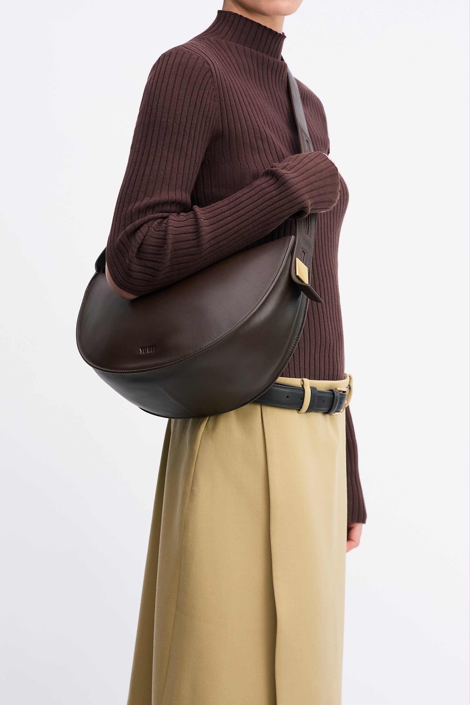 Antonia Bag in Molasses Lambskin worn cross-body by model in brown top and tan skirt