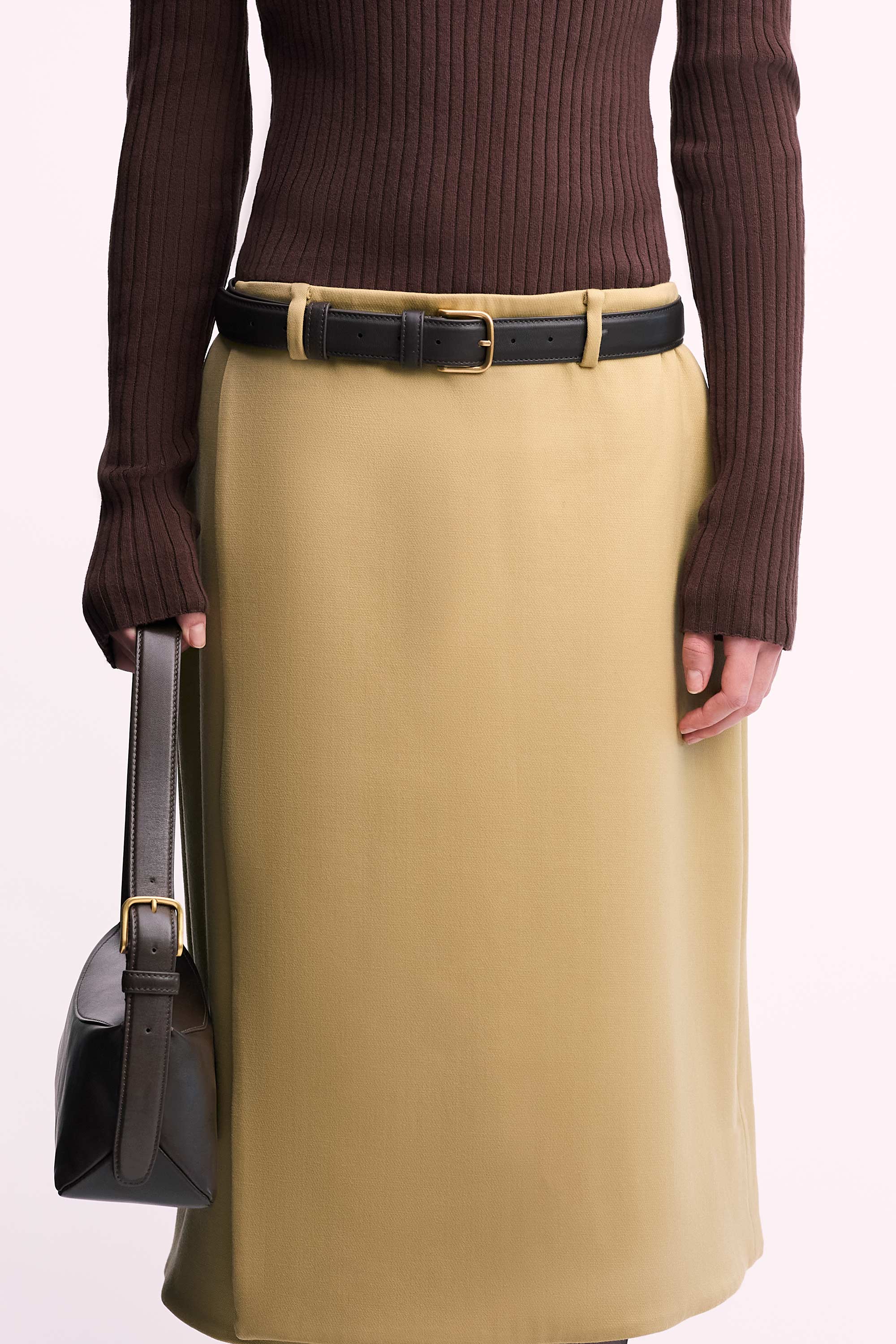 Bobby Bag in Americano Lambskin carried in model's hand wearing brown top and tan skirt