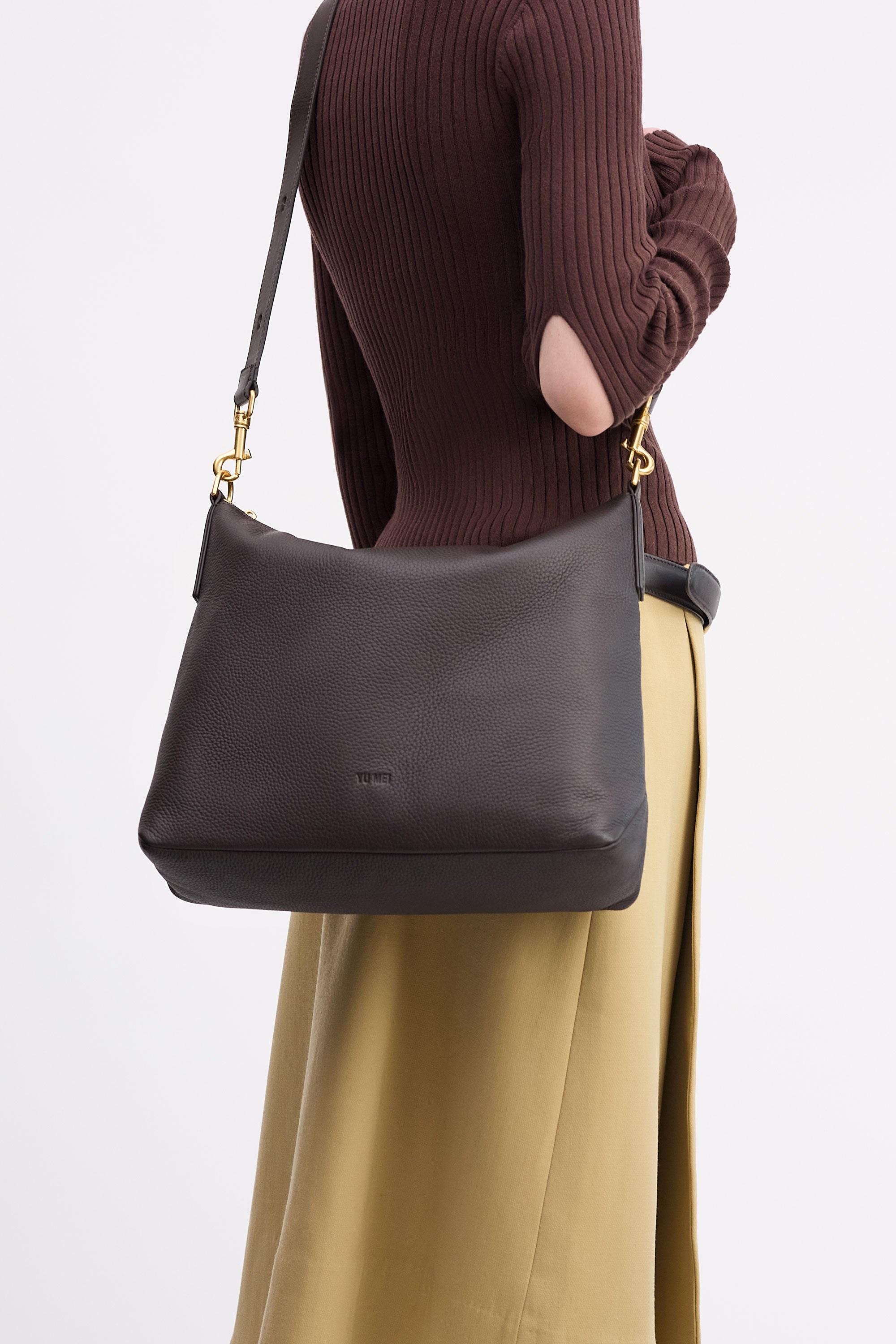 Braidy Bag in Americano Deer Nappa worn cross-body on person wearing brown top and tan skirt
