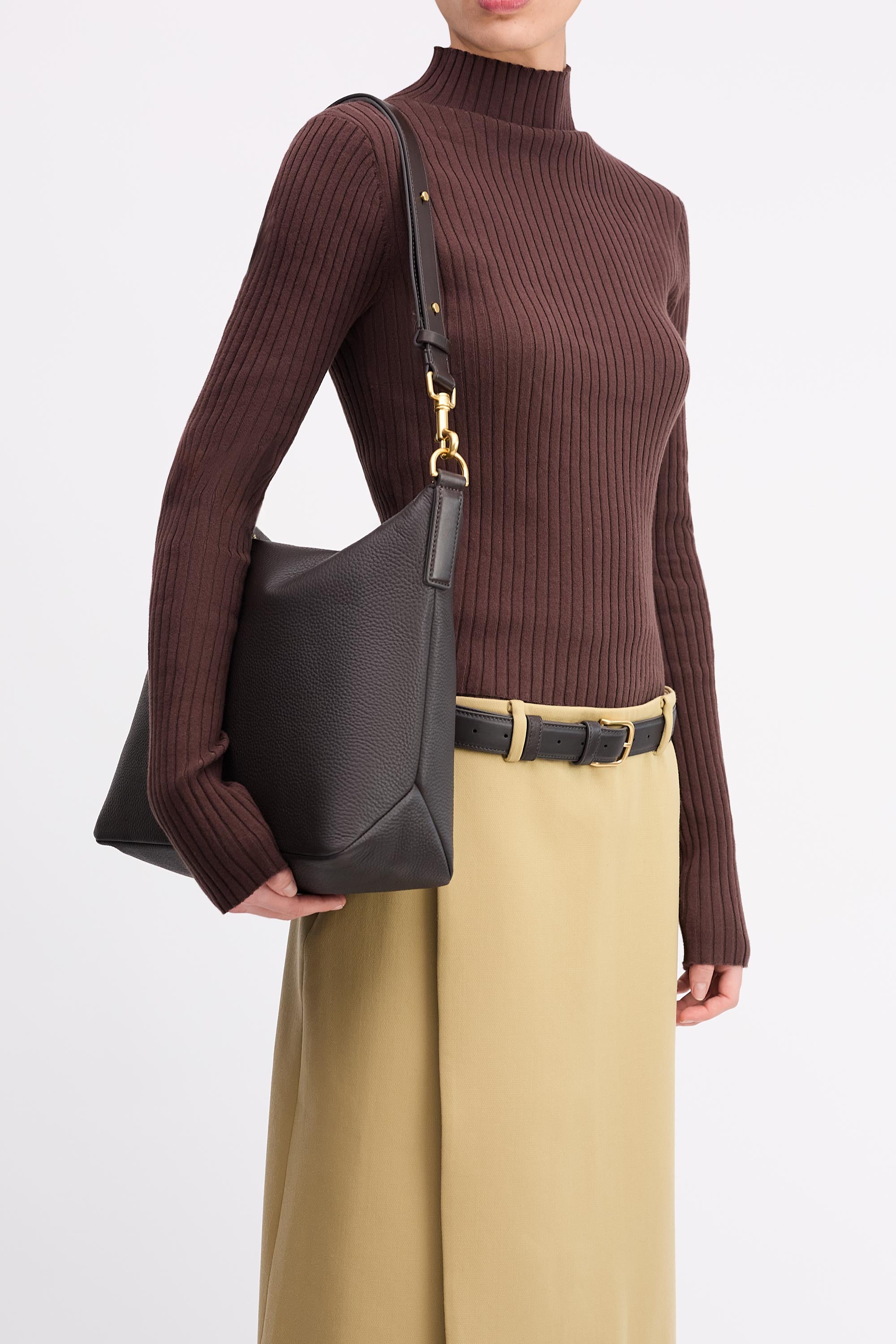 Braidy Bag in Americano Deer Nappa worn on shoulder of person wearing brown top and tan skirt
