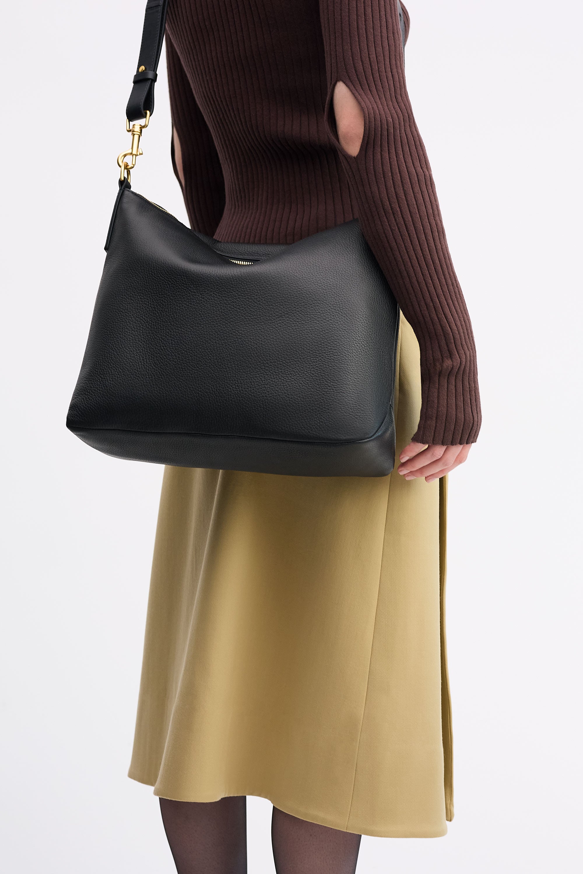 Yu Mei Braidy Bag in Black deer nappa worn on shoulder of model wearing brown top and tan skirt