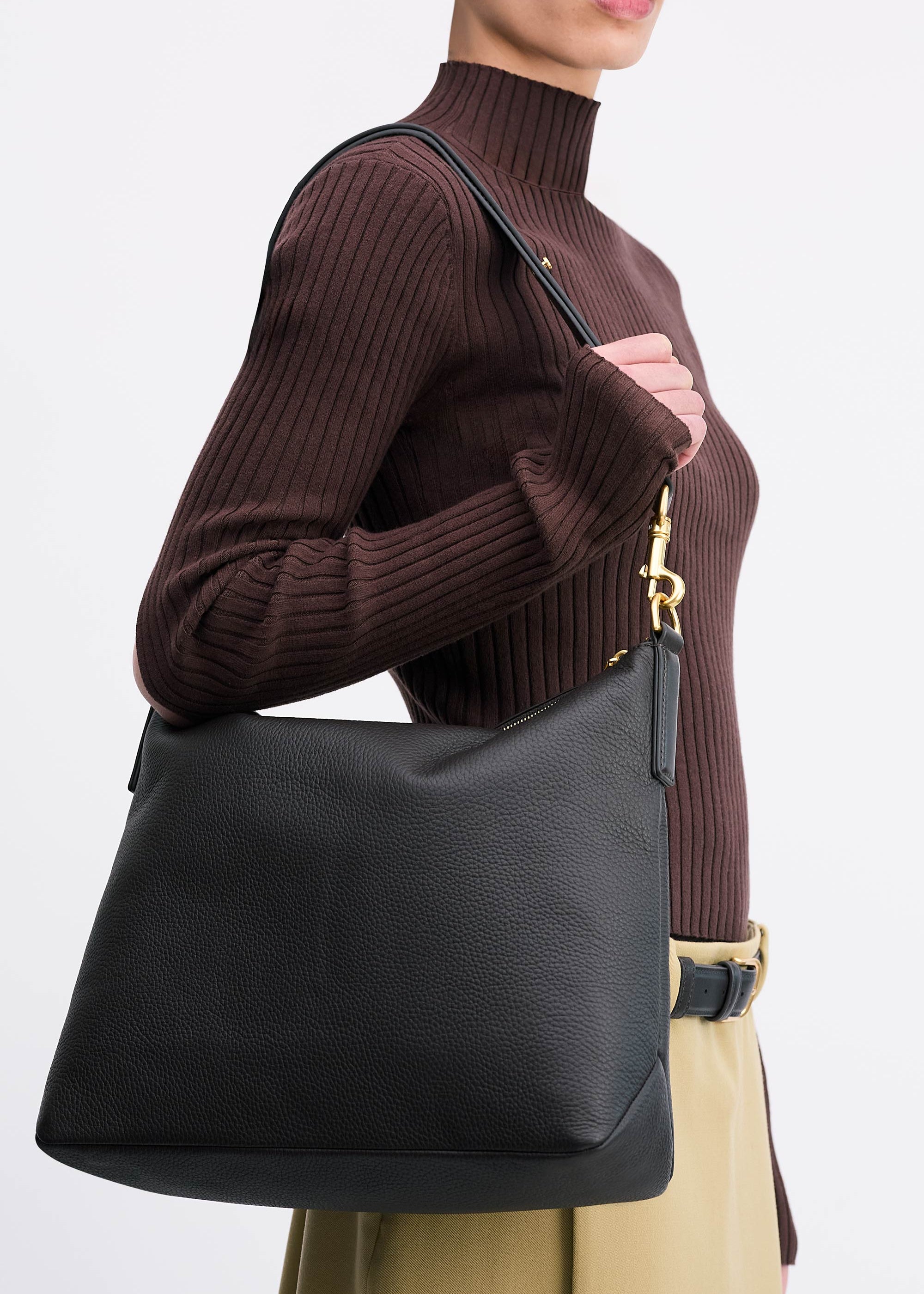 Yu Mei Braidy Bag in Black deer nappa worn on shoulder of model wearing brown top and tan skirt