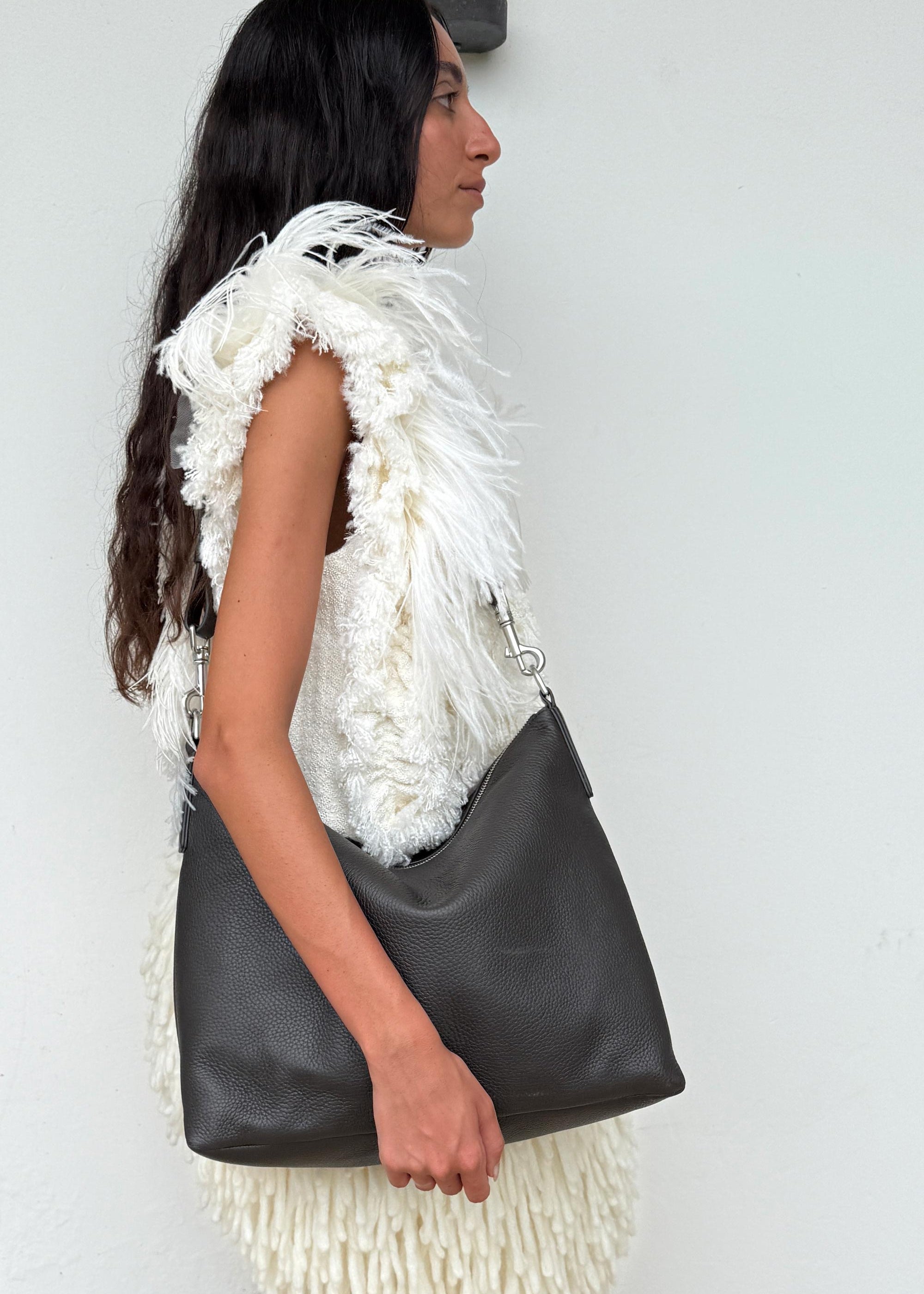 Model wearing the Braidy Bag in Black Olive deer nappa over shoulder