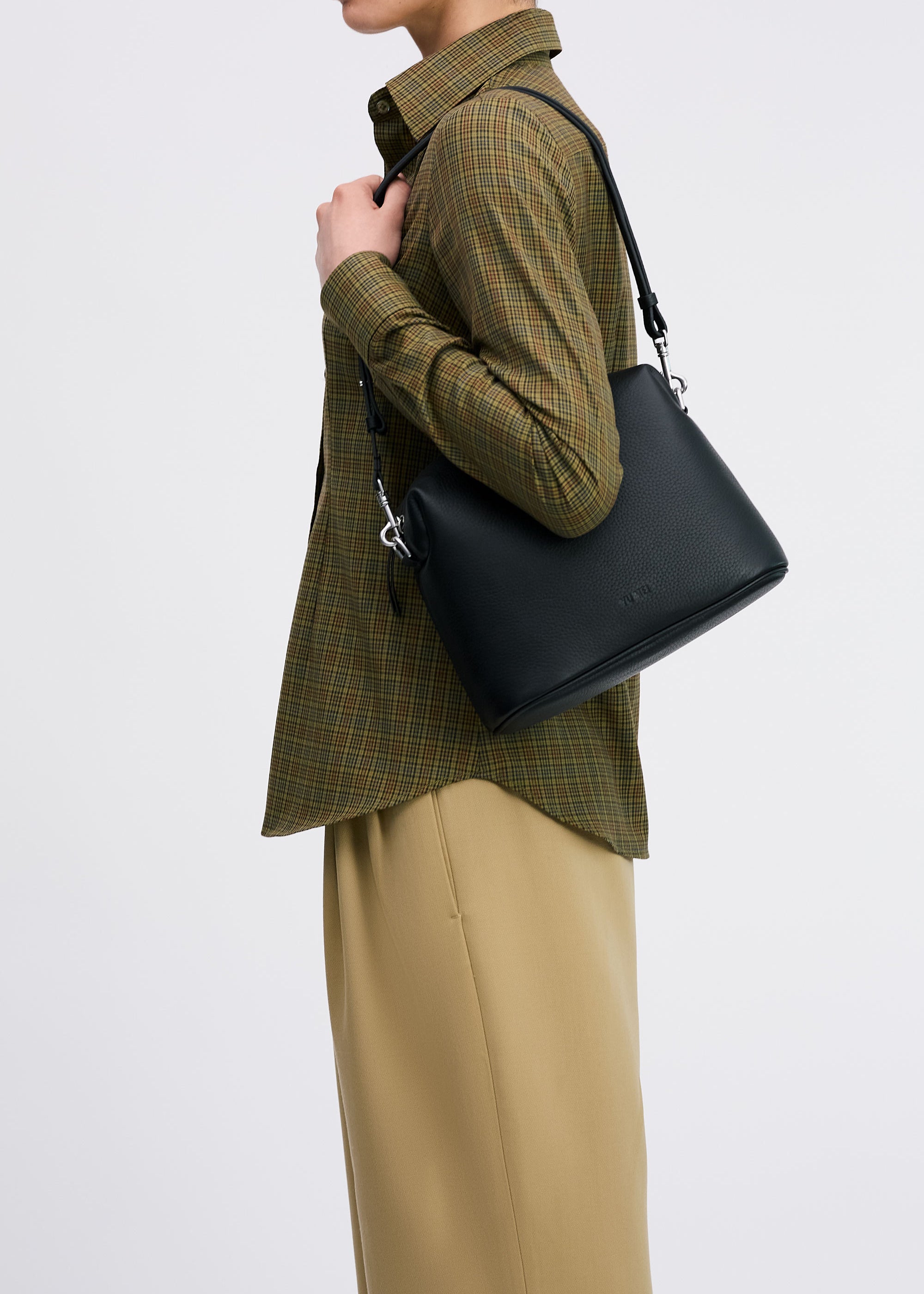 Ch'lita Bag in Black Deer Nappa on shoulder of model in check shirt and tan pants