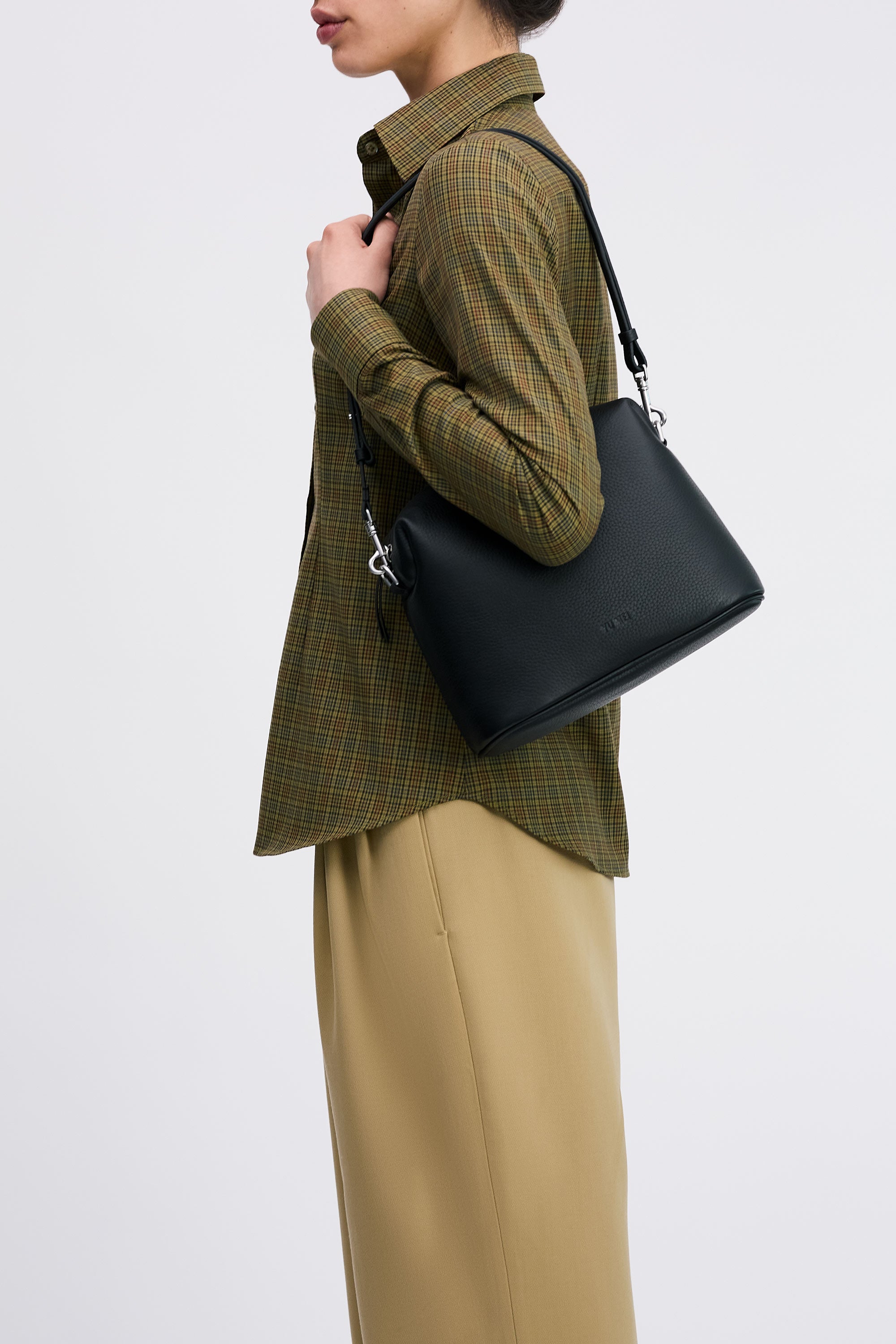 Ch'lita Bag in Black Deer Nappa on shoulder of model in check shirt and tan pants