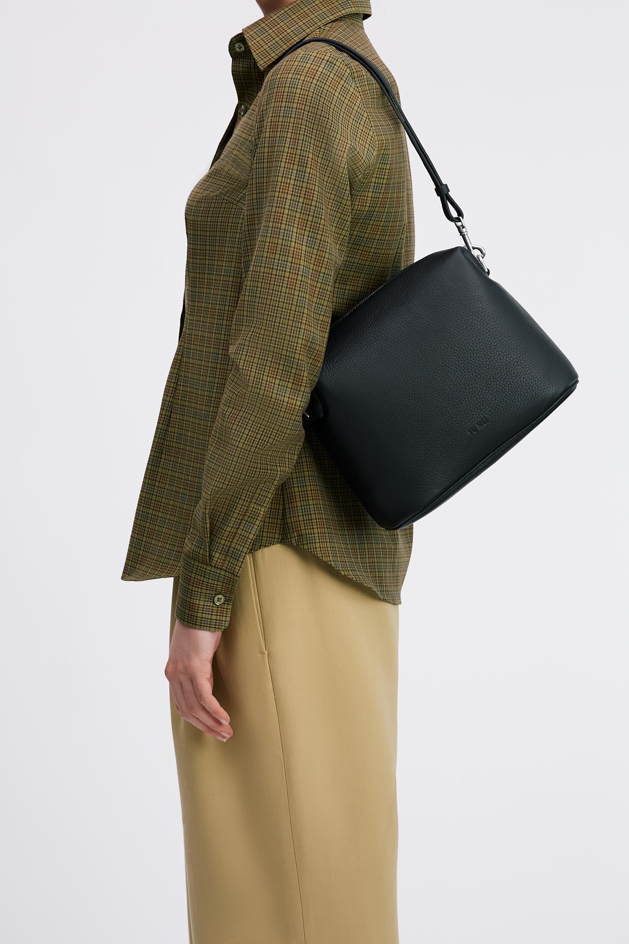 Ch'lita Bag in Black Deer Nappa on shoulder of model in check shirt and tan pants