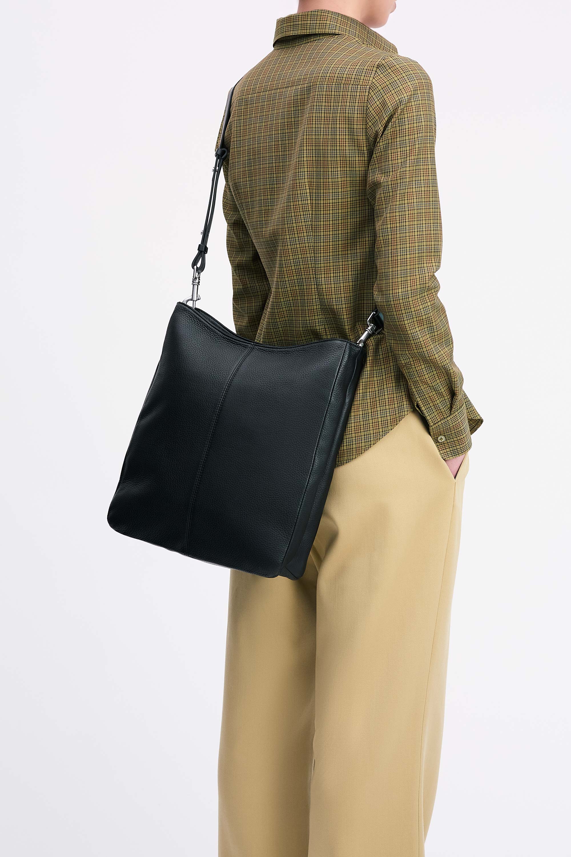 Model wearing the Jane Bag in Black deer nappa cross-body with check shirt and tan pants