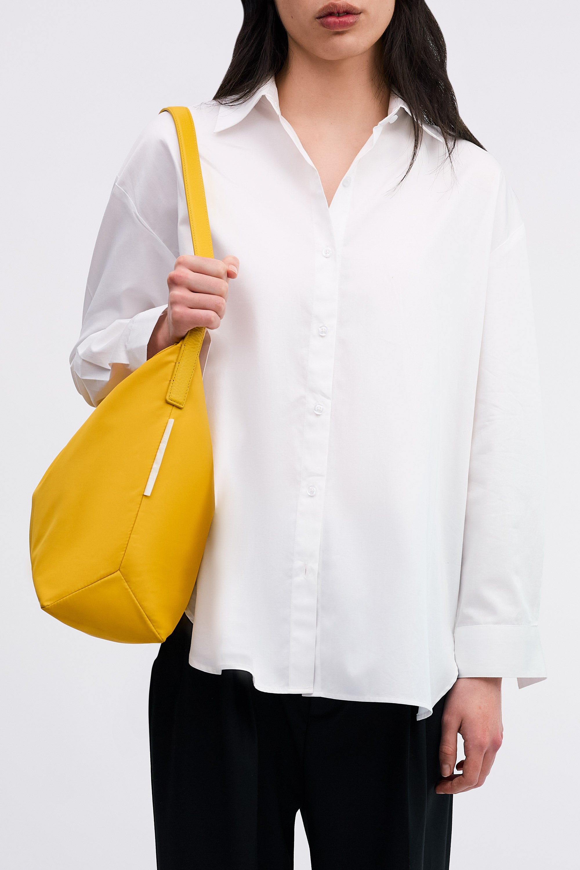 Model wearing the Medium UTILITY Braidy Bag in Honey nylon on shoulder wearing white shirt and black trousers front view