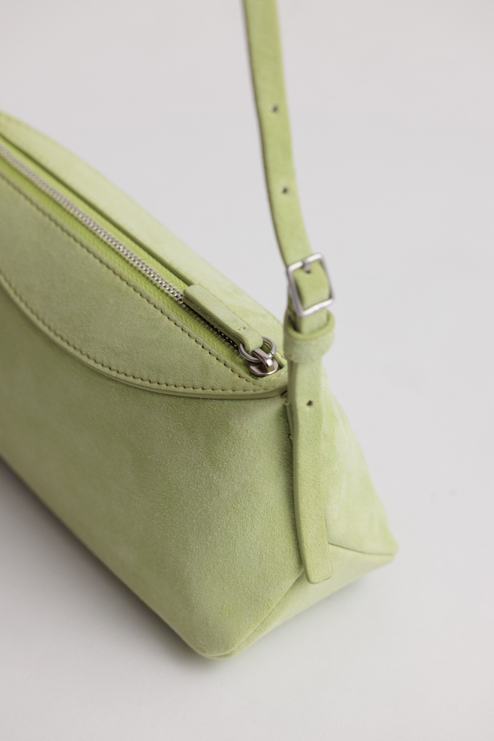 Yu Mei Mini Bobby in Apple Suede detailed view showing feathered belt style adjustable strap.