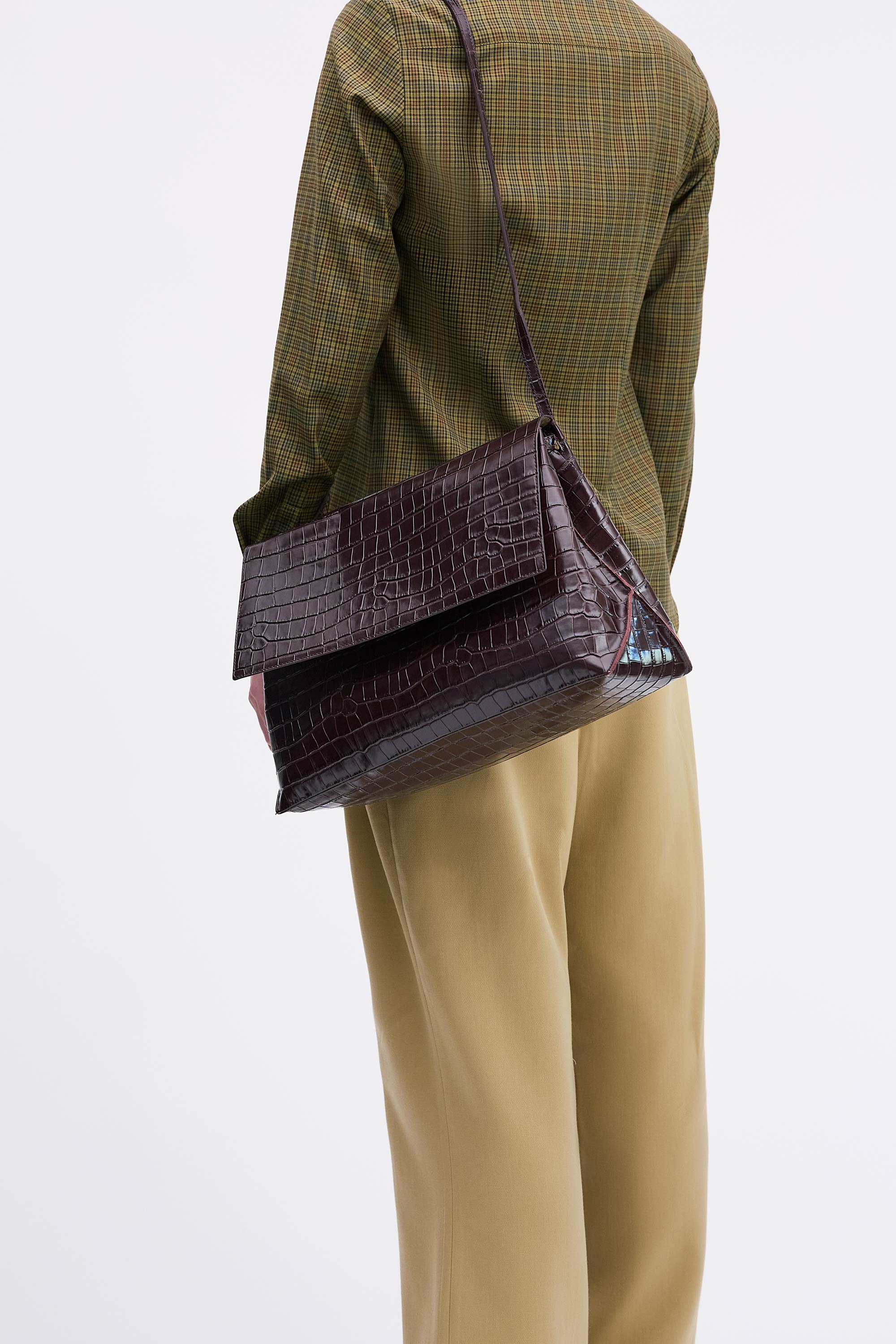 Back view of Pania Bag in Fire Croc worn on shoulder of model wearing check shirt and tan pants