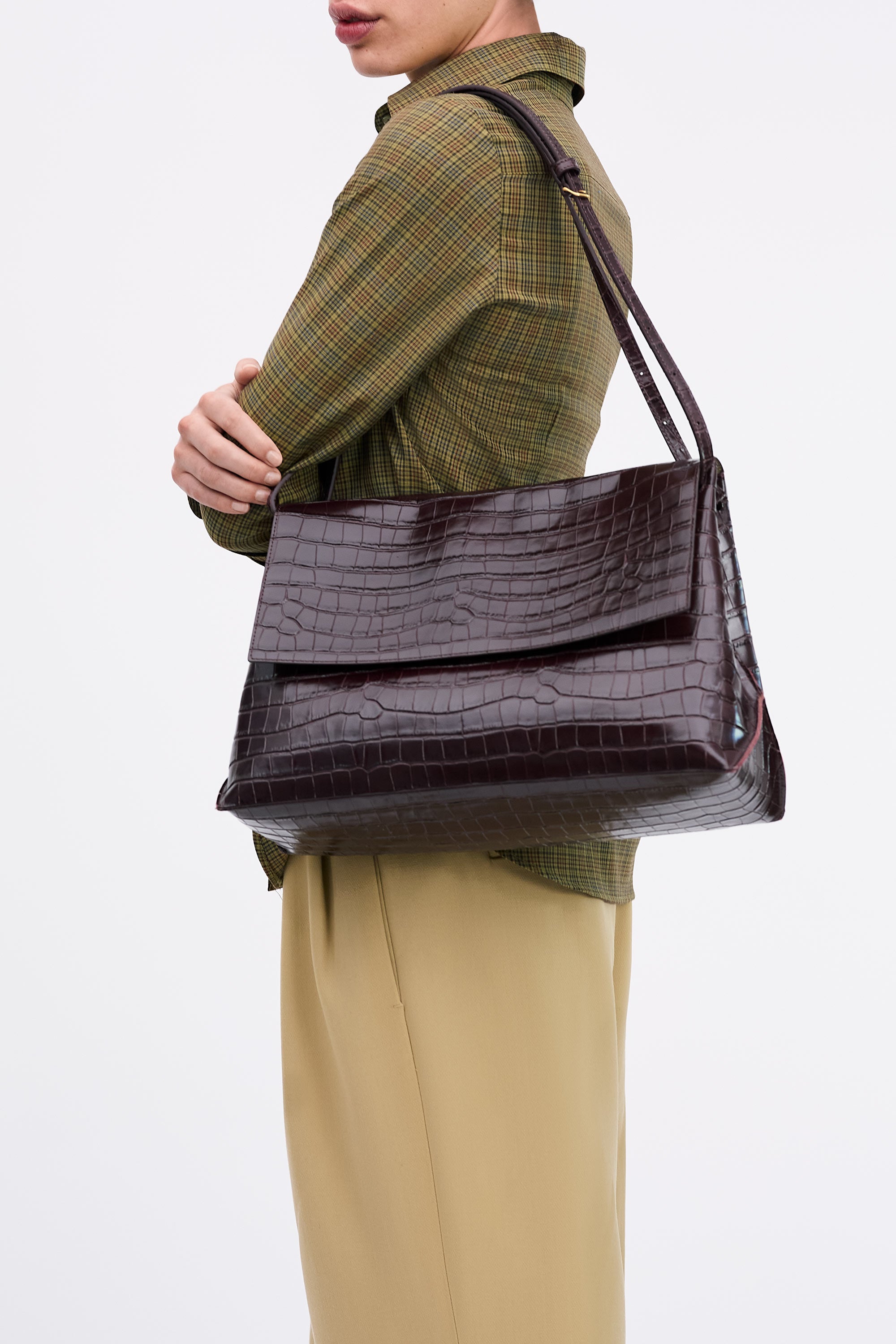 Side view of Pania Bag in Fire Croc worn on shoulder of model wearing check shirt and tan pants