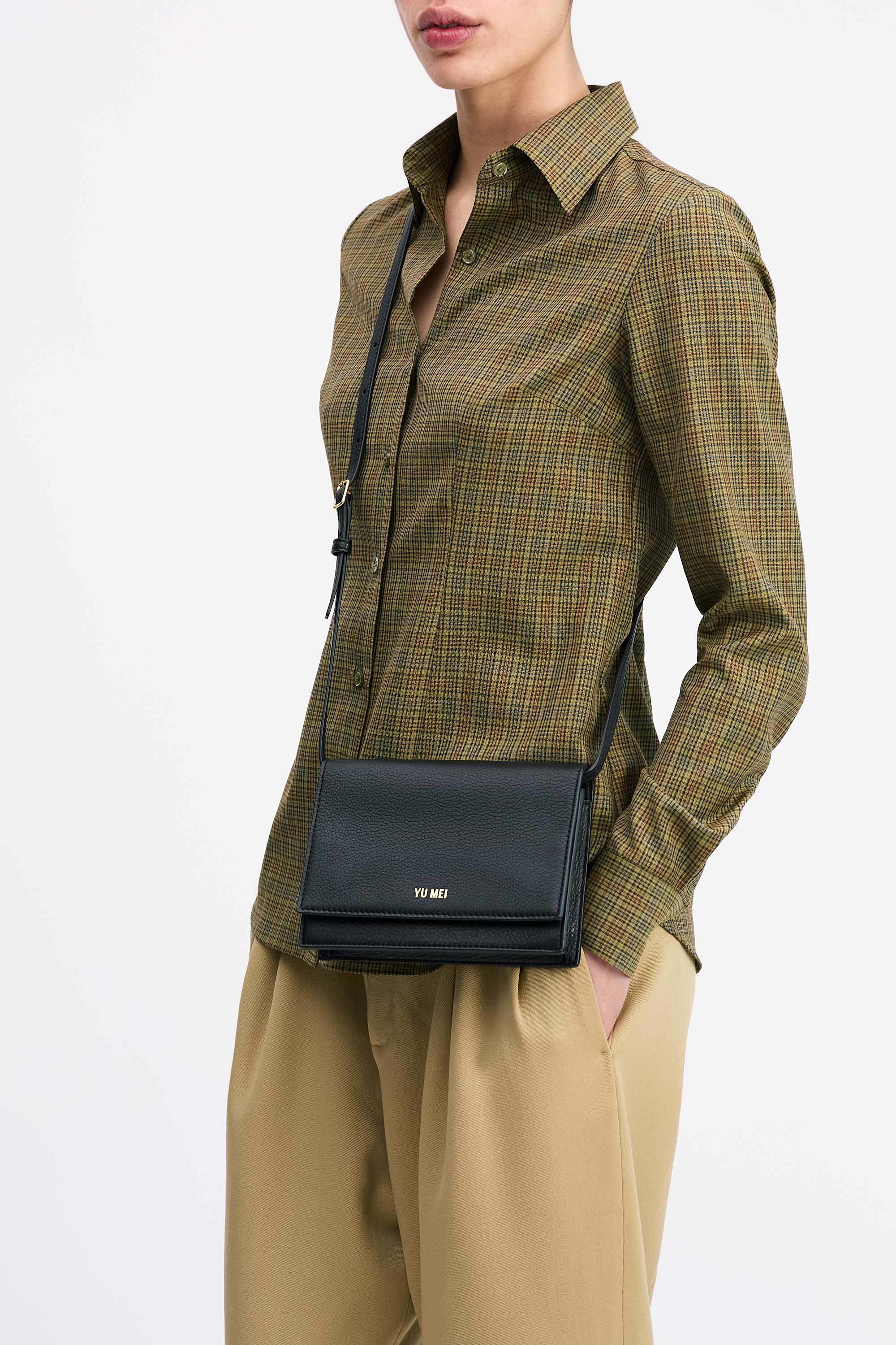 Suki Multi-Strap Clutch in Black Deer Nappa worn cross-body on model in check shirt and tan pants