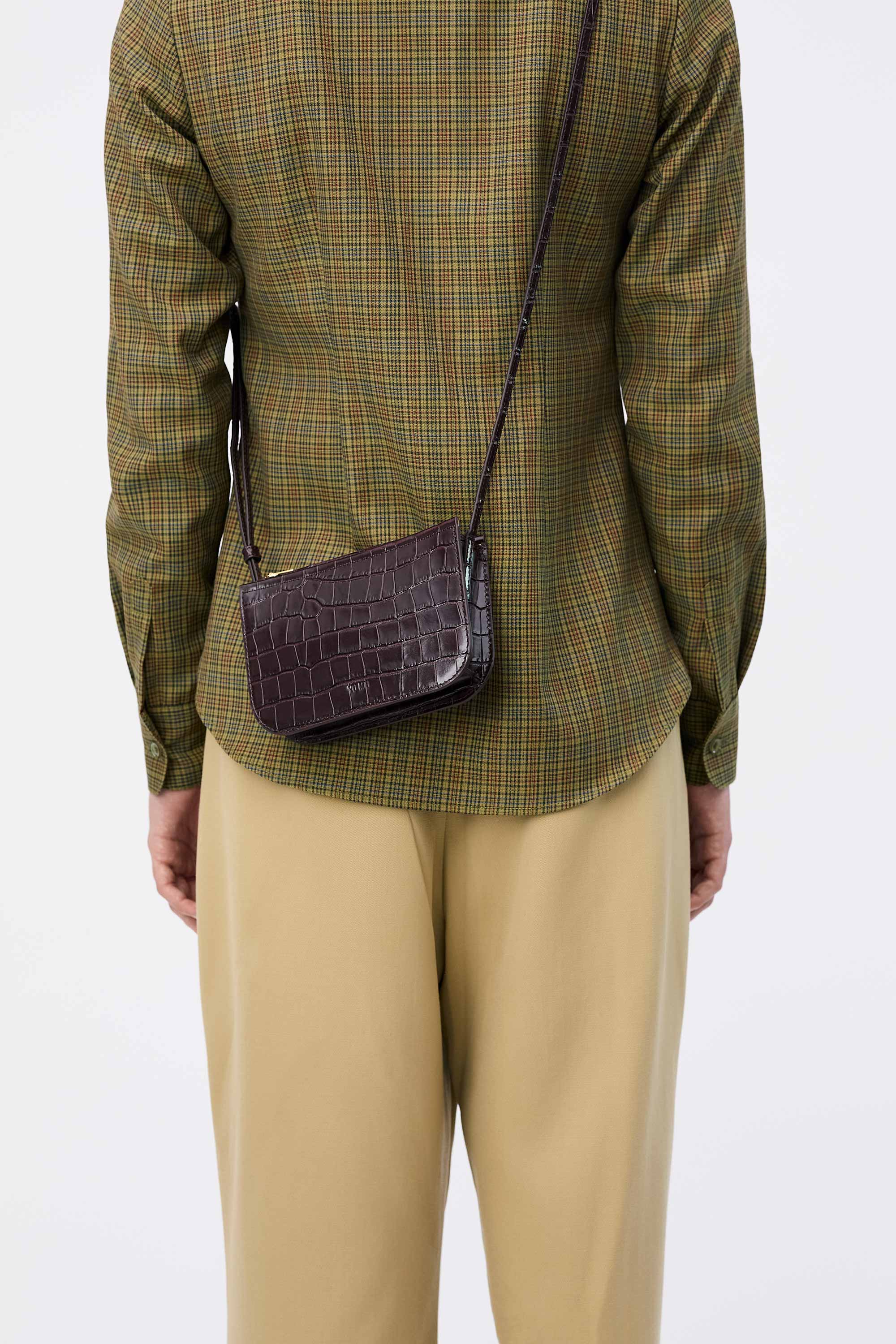 Back view of Vi Bag in Fire Croc worn cross-body on model wearing check shirt and tan pants