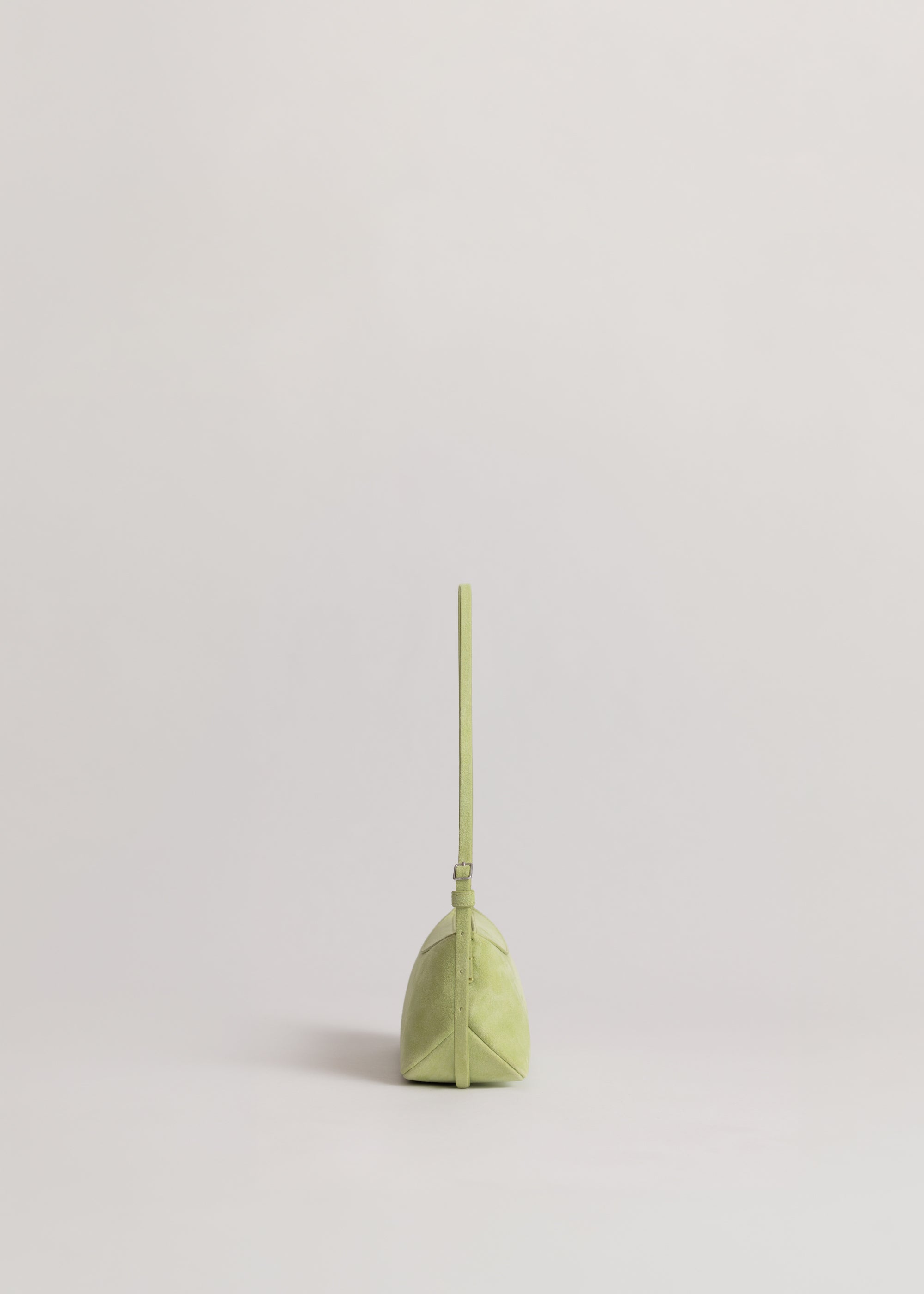 Yu Mei Mini Bobby in Apple Suede side view showing feathered belt style adjustable strap.