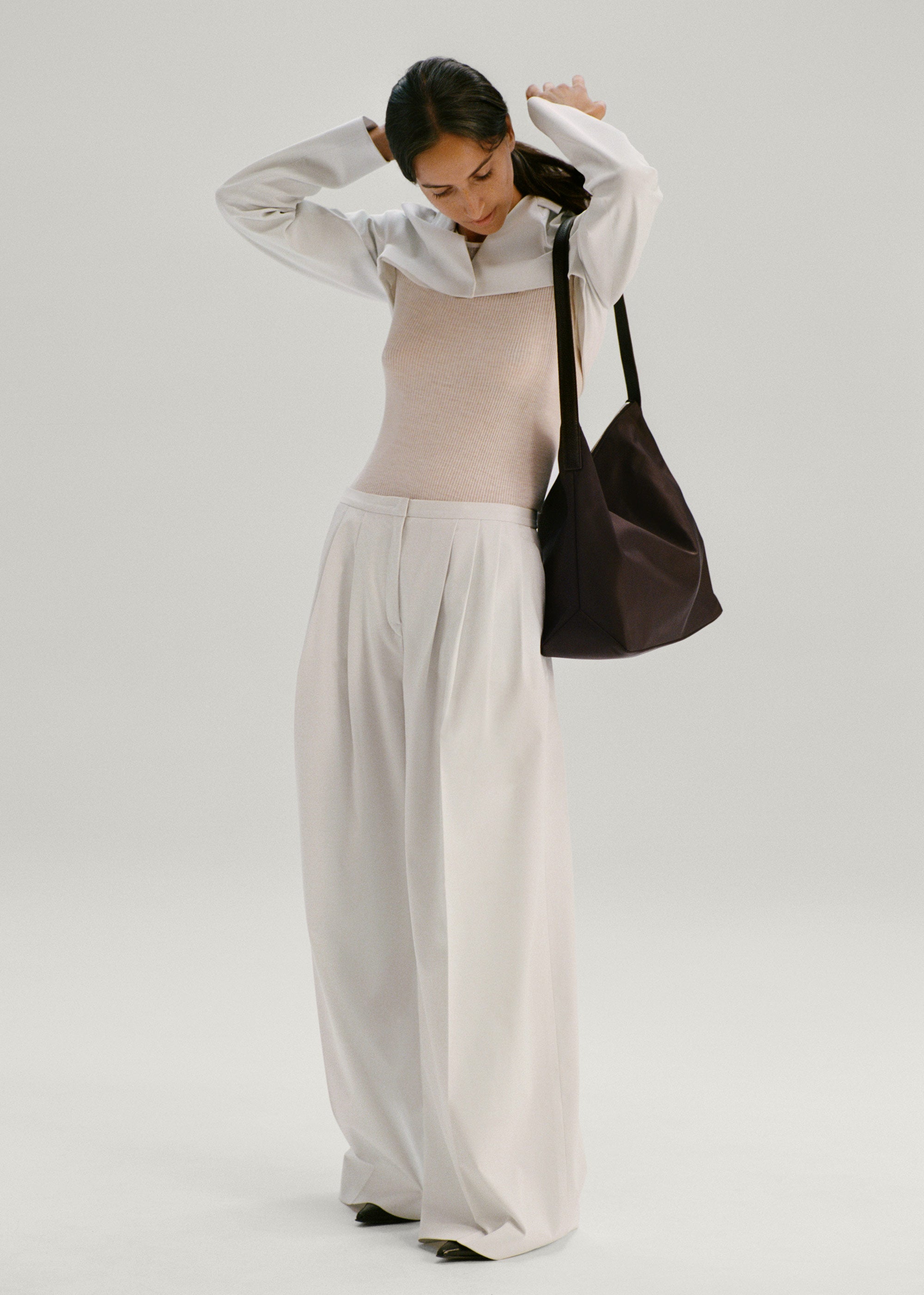 Model wearing the Medium UTILITY Braidy Bag in Coffee Bean nylon on shoulder wearing white outfit